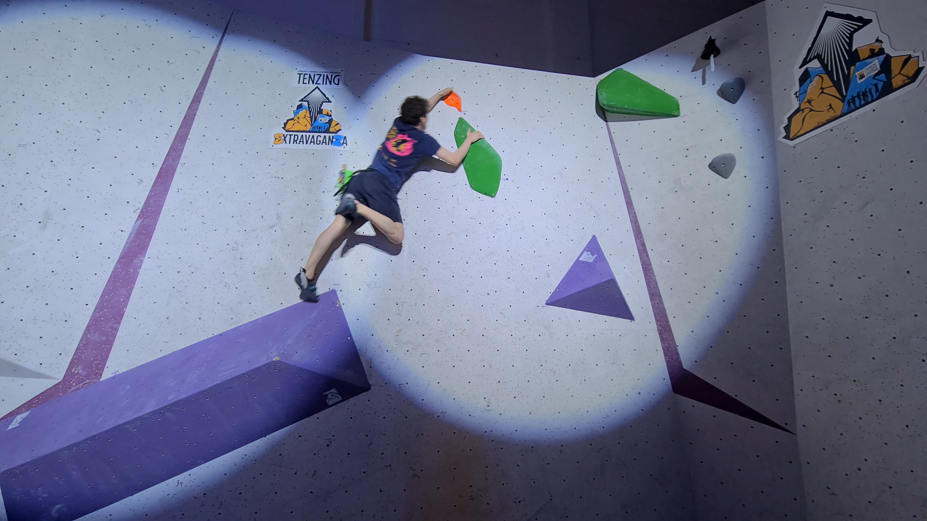 Blyth making a dynamic move on a competition-style boulder problem