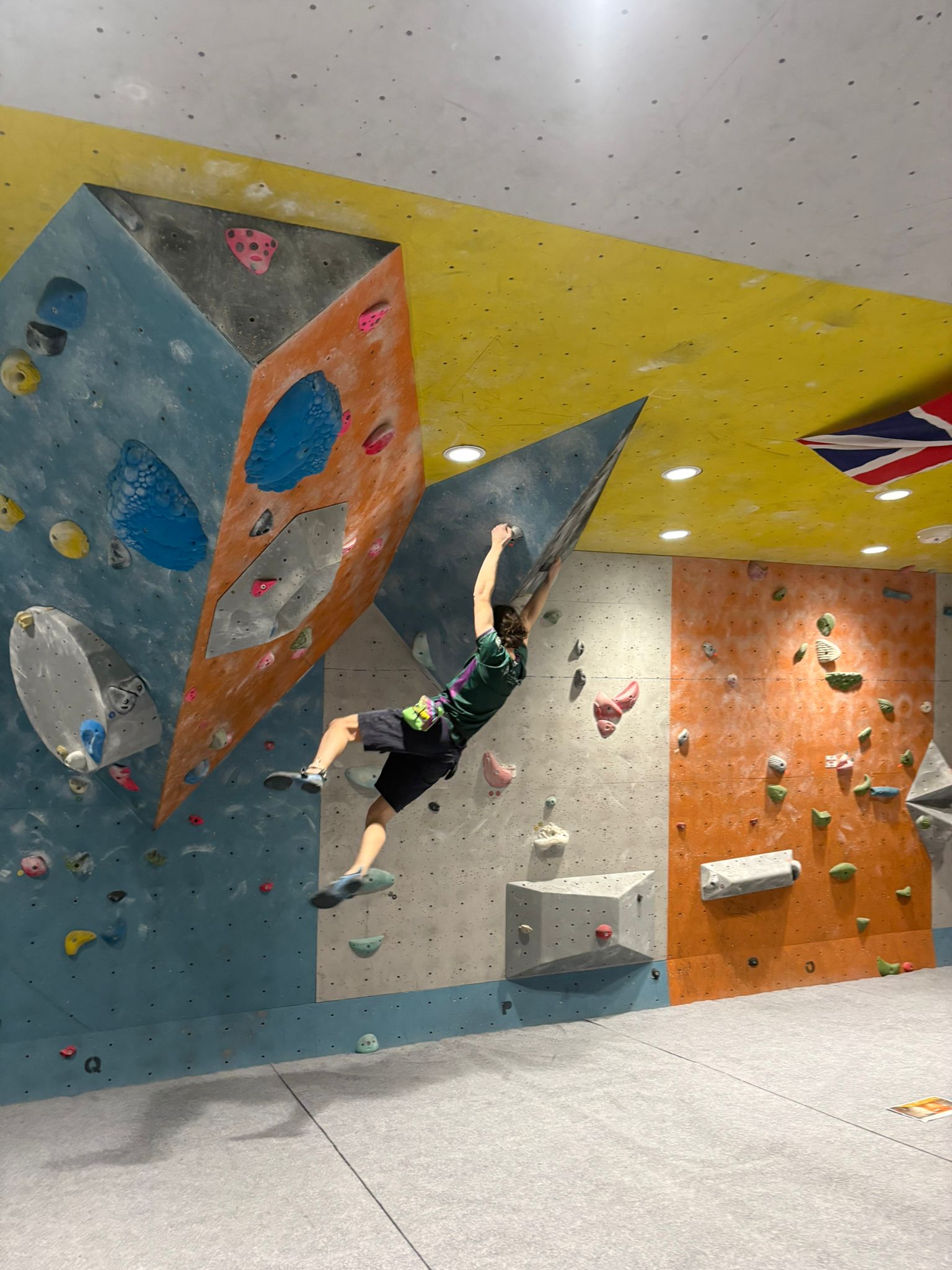 Blyth climbing on an indoor bouldering wall at varsity competitions